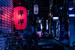 Alleyway in Kyoto Japan lit up by a red Japanese lantern.