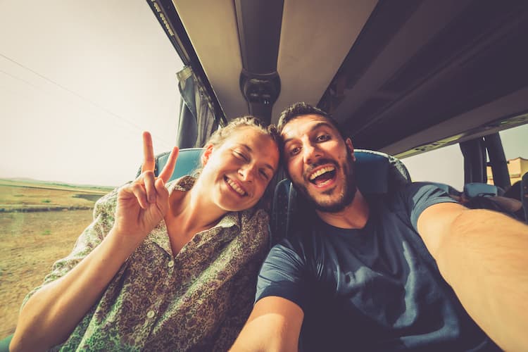 Two passengers on a bus ride taking a selfie.